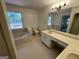 Bathroom featuring a garden tub under a stained glass window and a long vanity at 370 Rosetta Nw Ln, Conyers, GA 30012