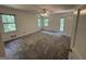 Large bedroom with neutral carpet, a ceiling fan, and a door leading to the outside at 370 Rosetta Nw Ln, Conyers, GA 30012