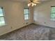 Bright bedroom with neutral carpet and a ceiling fan, with two windows providing great light at 370 Rosetta Nw Ln, Conyers, GA 30012