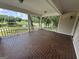 Spacious covered porch with brick flooring overlooking a serene pond and lush greenery at 370 Rosetta Nw Ln, Conyers, GA 30012