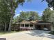 Inviting single-story home with a covered porch and a spacious carport nestled among lush trees at 370 Rosetta Nw Ln, Conyers, GA 30012