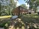 Two-story brick home with an external propane tank and a covered porch, set in a wooded landscape at 370 Rosetta Nw Ln, Conyers, GA 30012