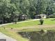 Picturesque view of a home with a pond, a well-maintained lawn, and mature trees in a serene setting at 370 Rosetta Nw Ln, Conyers, GA 30012