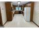 Spacious kitchen featuring wood cabinets, white refrigerator and patterned wallpaper at 370 Rosetta Nw Ln, Conyers, GA 30012