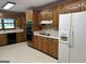 Traditional kitchen with wood cabinets, white refrigerator and countertops at 370 Rosetta Nw Ln, Conyers, GA 30012