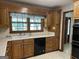 Traditional kitchen with wood cabinets, black appliances and a view to the outside at 370 Rosetta Nw Ln, Conyers, GA 30012