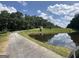 Scenic view of property featuring a tranquil pond reflecting the sky and lush green landscape at 370 Rosetta Nw Ln, Conyers, GA 30012