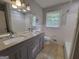 Bathroom featuring double sink vanity, tiled floors, and natural lighting from the window at 4157 Cedar Valley Ln, Conley, GA 30288