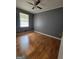 A bedroom featuring hardwood floors, a ceiling fan, and natural light from the window at 4157 Cedar Valley Ln, Conley, GA 30288