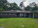 Charming brick ranch with solar panels on roof and well-manicured front yard at 4157 Cedar Valley Ln, Conley, GA 30288