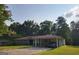 Single-story home with attached carport, solar panels, and lush green lawn at 4157 Cedar Valley Ln, Conley, GA 30288