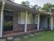Charming front porch with brick and tile details, featuring a security screen door at 4157 Cedar Valley Ln, Conley, GA 30288