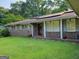 Inviting brick home with solar panels on the roof and a well-kept green lawn at 4157 Cedar Valley Ln, Conley, GA 30288