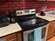 Close-up of a black electric range with stainless steel appliances and light countertops at 4157 Cedar Valley Ln, Conley, GA 30288
