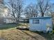 Backyard view of a mobile home with a covered porch, surrounded by bare trees at 225 Bell St, Covington, GA 30016