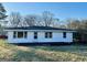 Rear view of a white home with a black roof and small black deck at 225 Bell St, Covington, GA 30016