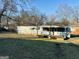 Wide shot showing exterior of older single-wide trailer with small porch at 225 Bell St, Covington, GA 30016