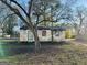 Exterior view of a weathered shed with a tree in front at 225 Bell St, Covington, GA 30016