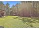 Expansive backyard with lush green lawn, mature trees, and a charming storage shed, perfect for outdoor enjoyment at 211 Beavers Rd, Grantville, GA 30220