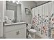 Well-lit bathroom with a modern vanity, floral shower curtain and convenient toilet at 211 Beavers Rd, Grantville, GA 30220