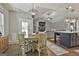 Open-concept dining area featuring a wooden table set beneath a modern chandelier, flowing into the living room and kitchen at 211 Beavers Rd, Grantville, GA 30220