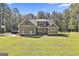 Inviting home featuring a well-maintained lawn and a classic facade with stone accents and black trim windows at 211 Beavers Rd, Grantville, GA 30220