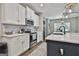 Bright kitchen with white cabinets, stainless steel appliances, and an island with a sink and seating at 211 Beavers Rd, Grantville, GA 30220