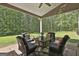 Inviting covered patio featuring comfortable seating and a tranquil view of the lush backyard and surrounding nature at 211 Beavers Rd, Grantville, GA 30220