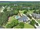 Aerial view of the property, with pool and landscaping, nestled among mature trees near a pond at 30 Dorset Ct, Sharpsburg, GA 30277
