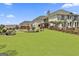 Spacious backyard featuring green lawn, landscaping, and large estate at 30 Dorset Ct, Sharpsburg, GA 30277