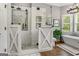 Bathroom showcasing a freestanding tub, glass enclosed shower, mosaic tile, and a barn door at 30 Dorset Ct, Sharpsburg, GA 30277
