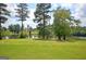 Scenic lake view with lush green lawn and mature trees reflecting in the calm water at 30 Dorset Ct, Sharpsburg, GA 30277