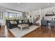 Bright and cozy living room with a large sofa, decorative fireplace, and open staircase leading to the upper level at 30 Dorset Ct, Sharpsburg, GA 30277