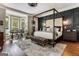 Primary bedroom with hardwood floors, bay windows, dark accent wall and a four-poster bed at 30 Dorset Ct, Sharpsburg, GA 30277