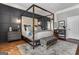 Main bedroom with a four poster bed, hardwood floors and dark accent wall at 30 Dorset Ct, Sharpsburg, GA 30277