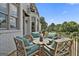 Outdoor patio with a set of four wooden chairs, a table, a balcony and stone pavers at 30 Dorset Ct, Sharpsburg, GA 30277