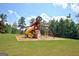 A well-maintained community playground with a slide, climbing wall, and swing set on green grass at 30 Dorset Ct, Sharpsburg, GA 30277