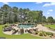 Inviting pool area featuring a rock waterfall, mature trees, comfortable lounge seating, and lush landscaping at 30 Dorset Ct, Sharpsburg, GA 30277