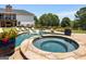 Beautiful pool with a raised spa and comfortable lounge chairs on the stone deck, ideal for relaxation at 30 Dorset Ct, Sharpsburg, GA 30277