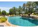 Inviting swimming pool with waterfall feature, lush landscaping, and sun loungers for relaxation at 30 Dorset Ct, Sharpsburg, GA 30277