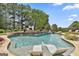 Beautiful outdoor pool with a stone waterfall feature and serene lounge chairs at 30 Dorset Ct, Sharpsburg, GA 30277