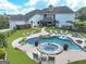 A luxurious backyard pool area with a spa, lounge chairs, and a covered outdoor dining space at 30 Dorset Ct, Sharpsburg, GA 30277