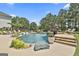 Beautiful swimming pool with a waterfall feature, surrounded by lush landscaping and lounge areas at 30 Dorset Ct, Sharpsburg, GA 30277