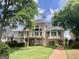 Back exterior of a brick home with a spacious deck, large windows, and lush greenery in a serene setting at 103 Golf Terrace Dr, Stockbridge, GA 30281