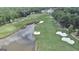 Aerial view of a meticulously manicured golf course with a pond, sand traps, and community clubhouse at 103 Golf Terrace Dr, Stockbridge, GA 30281