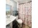 Bathroom features a shower with Eiffel Tower-themed curtain, sink, toilet and shelving for storage at 1766 Tilden Ave, Jonesboro, GA 30236
