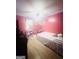 Bright pink bedroom features a light wood floor, rainbow decor, and a ceiling fan with lights at 1766 Tilden Ave, Jonesboro, GA 30236