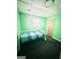 Green bedroom with a white twin bed, carpet floors, natural light, and a wooden door at 1766 Tilden Ave, Jonesboro, GA 30236
