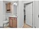 A half bathroom with wood cabinets, a white sink, and an open door to a closet at 106 Lanyard Bnd, Peachtree City, GA 30269