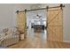 Open concept living room with hard wood floors and dining area seen through sliding barn doors at 106 Lanyard Bnd, Peachtree City, GA 30269